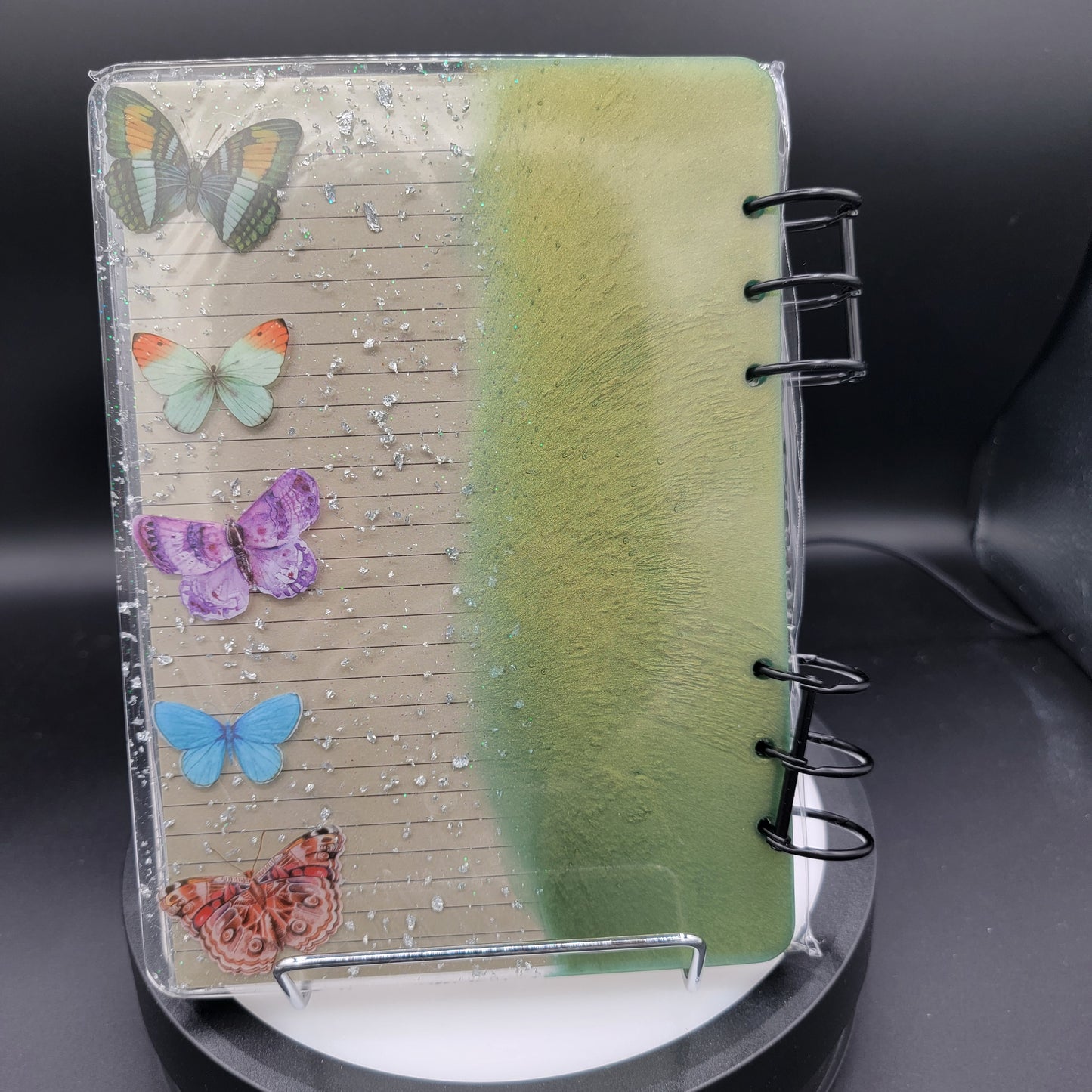 Notebook with colorful butterfly stickers on a black background