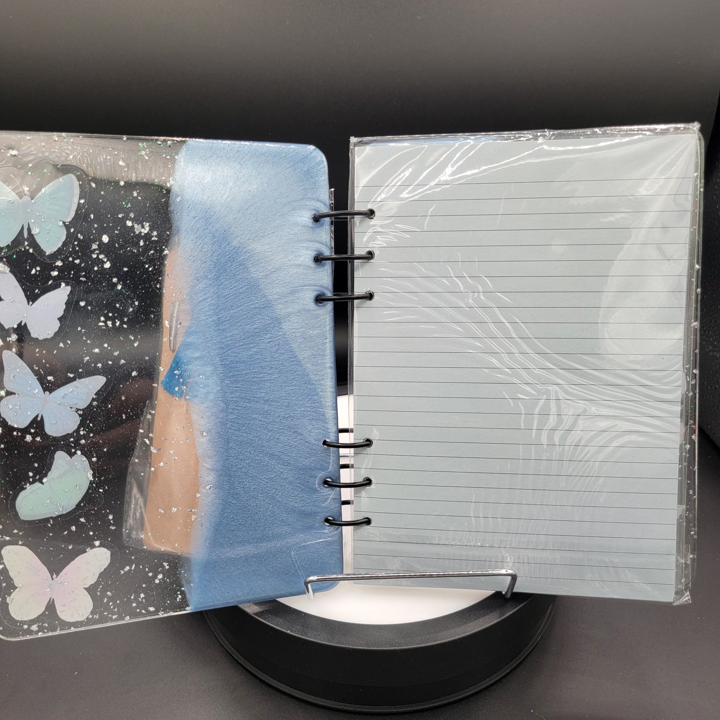 Notebook with butterfly design on cover, clear plastic wrap on top