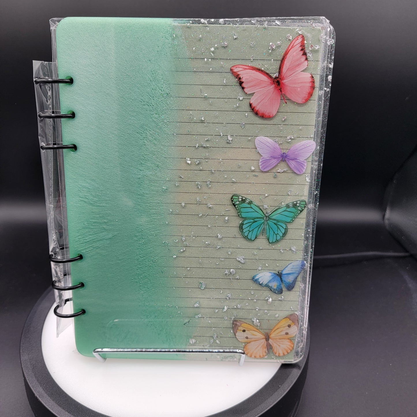 Notebook with colorful butterfly stickers on a black background