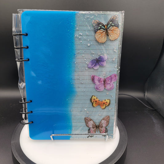 Notebook with butterfly designs on a blue background