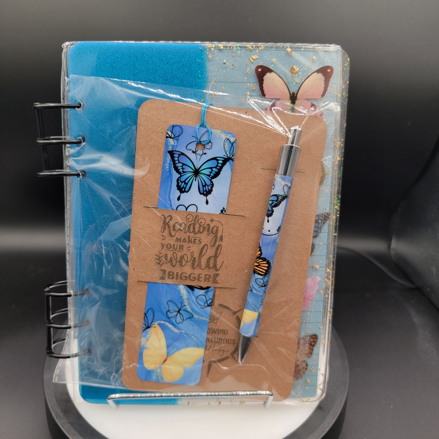 Notebook with butterfly-themed cover and stickers on a dark surface