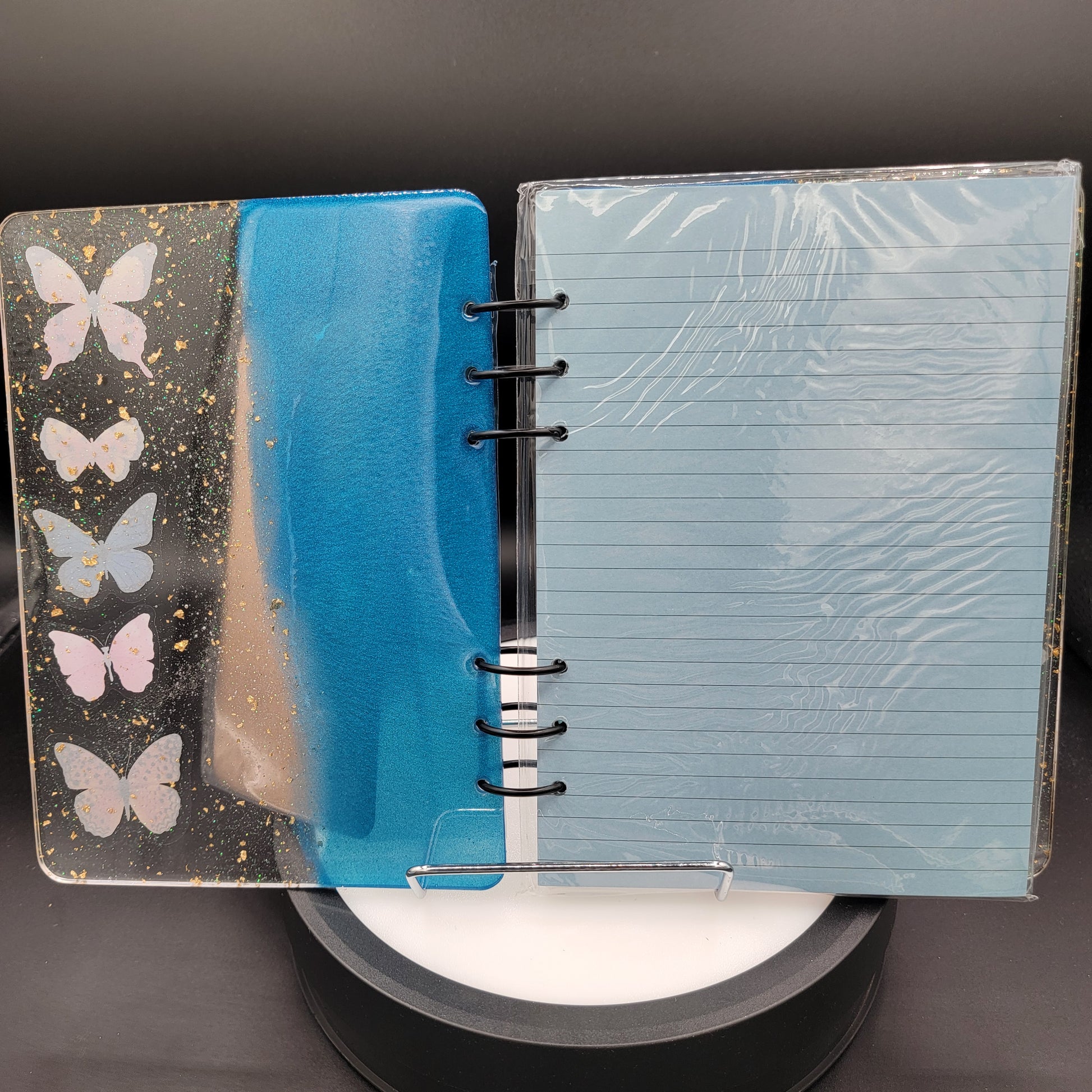 Notebook with blue watercolor design and butterfly illustrations on a gray background
