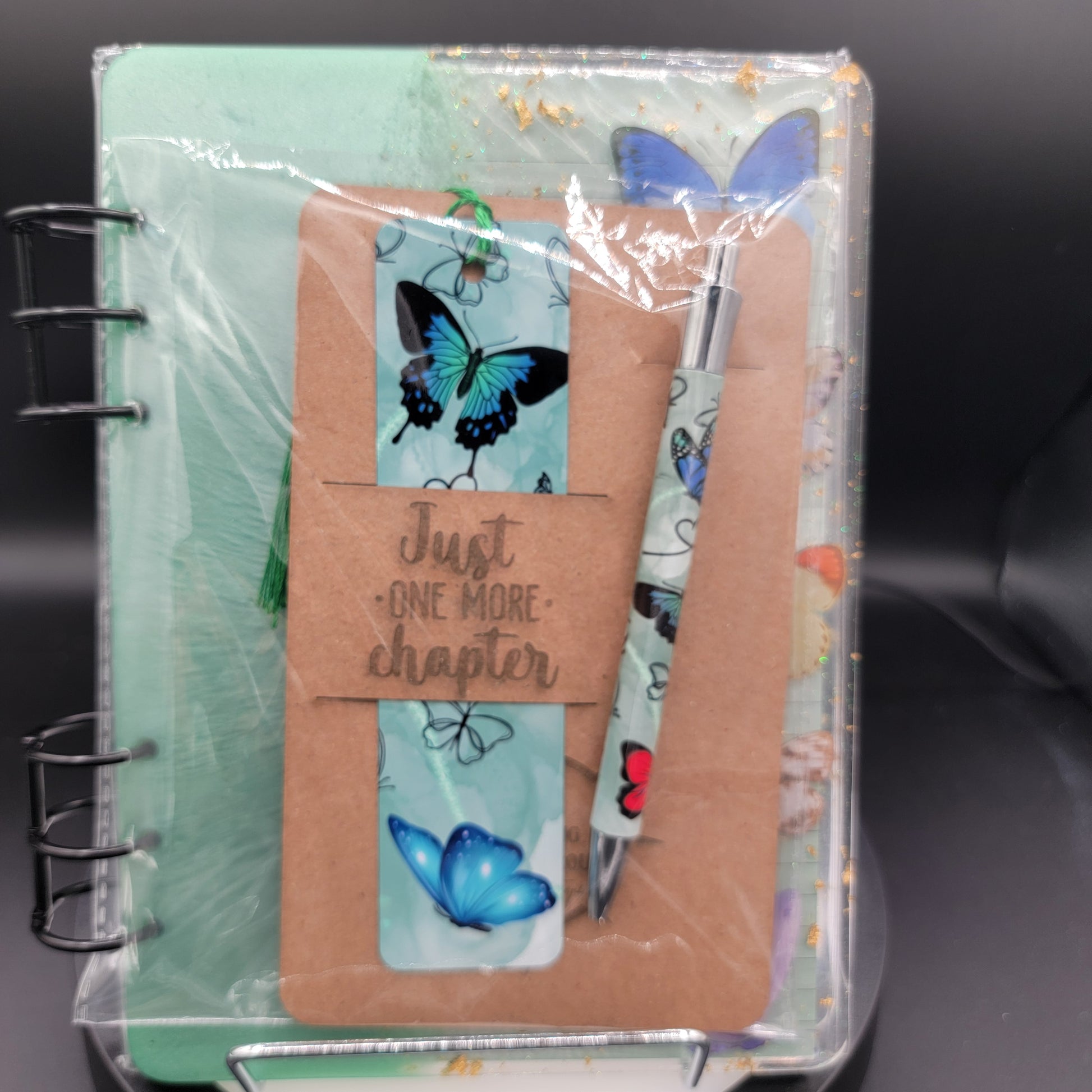 Notebook set with pen, bookmarks, and stickers on a black background