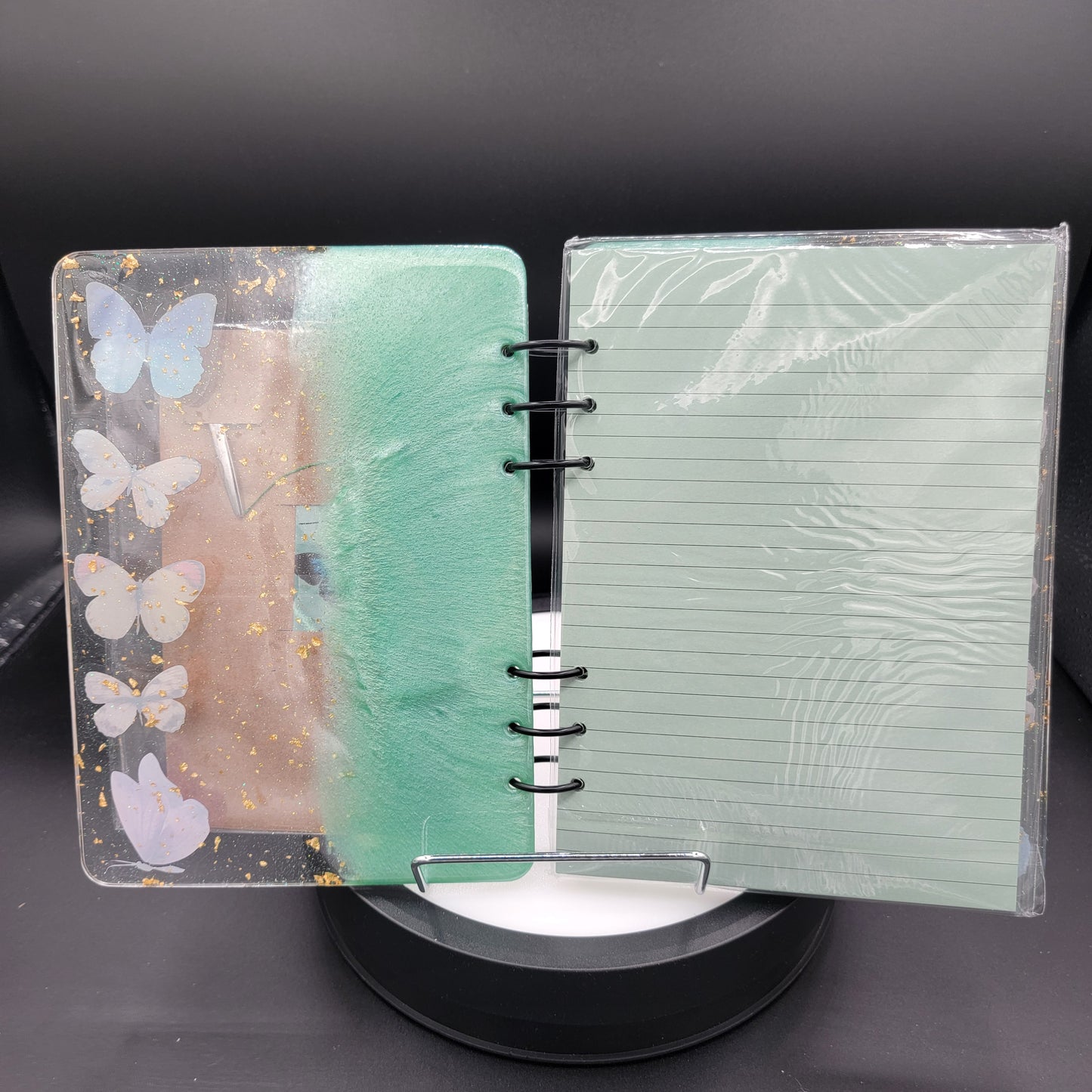 Notebook with butterfly design on cover and green textured page inside