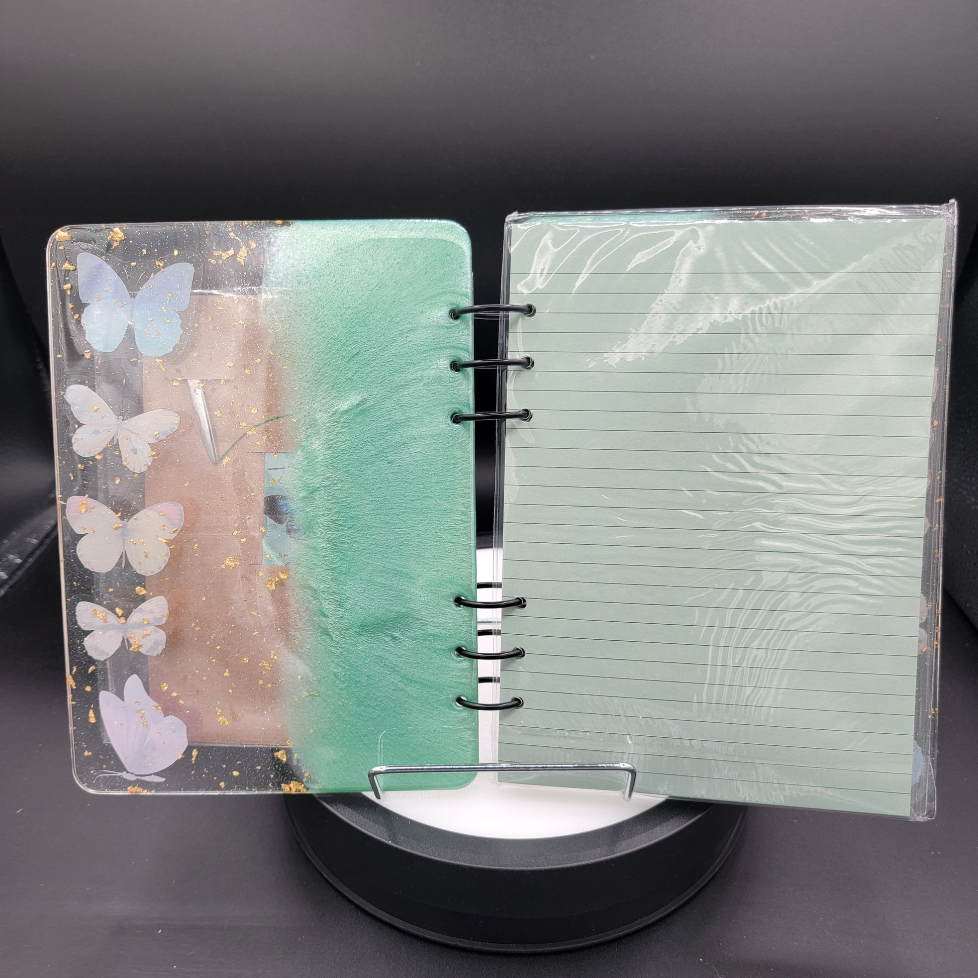 Notebook with butterfly design on cover and green textured page inside