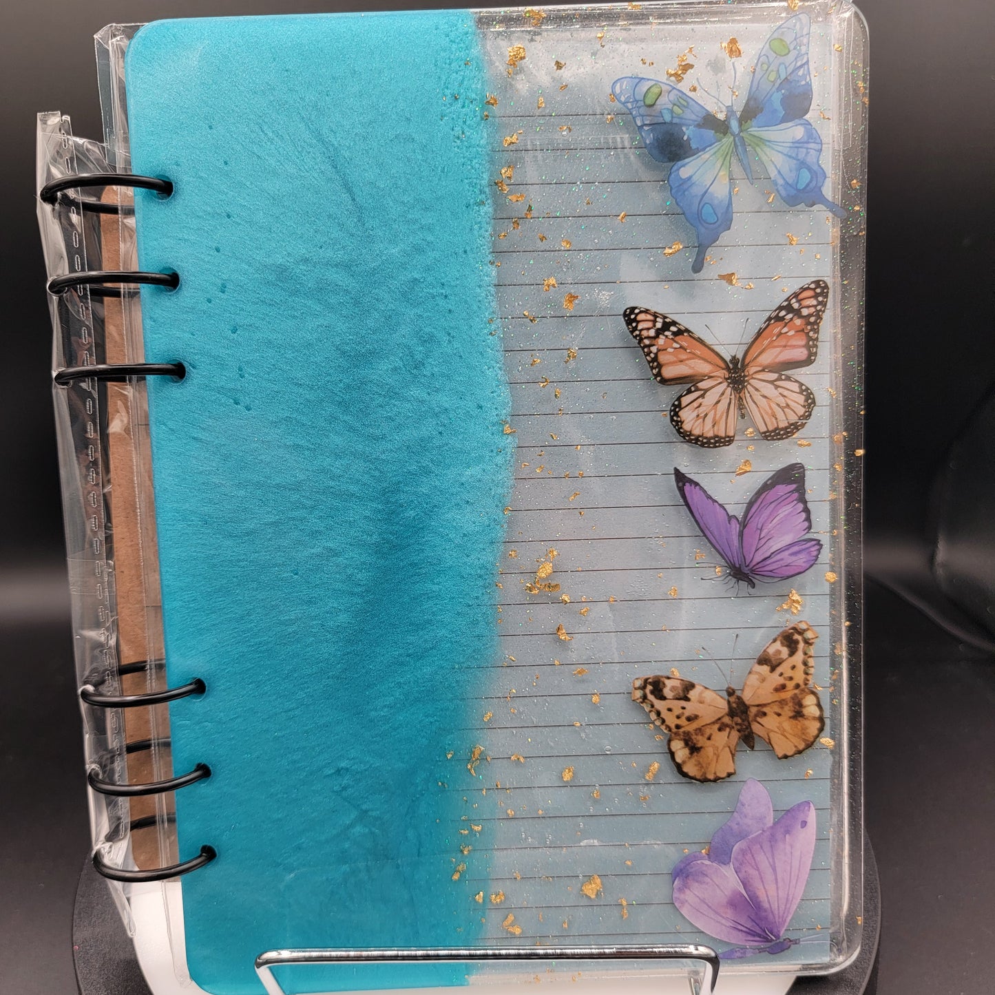 Notebook with butterfly designs on a clear cover against a dark background