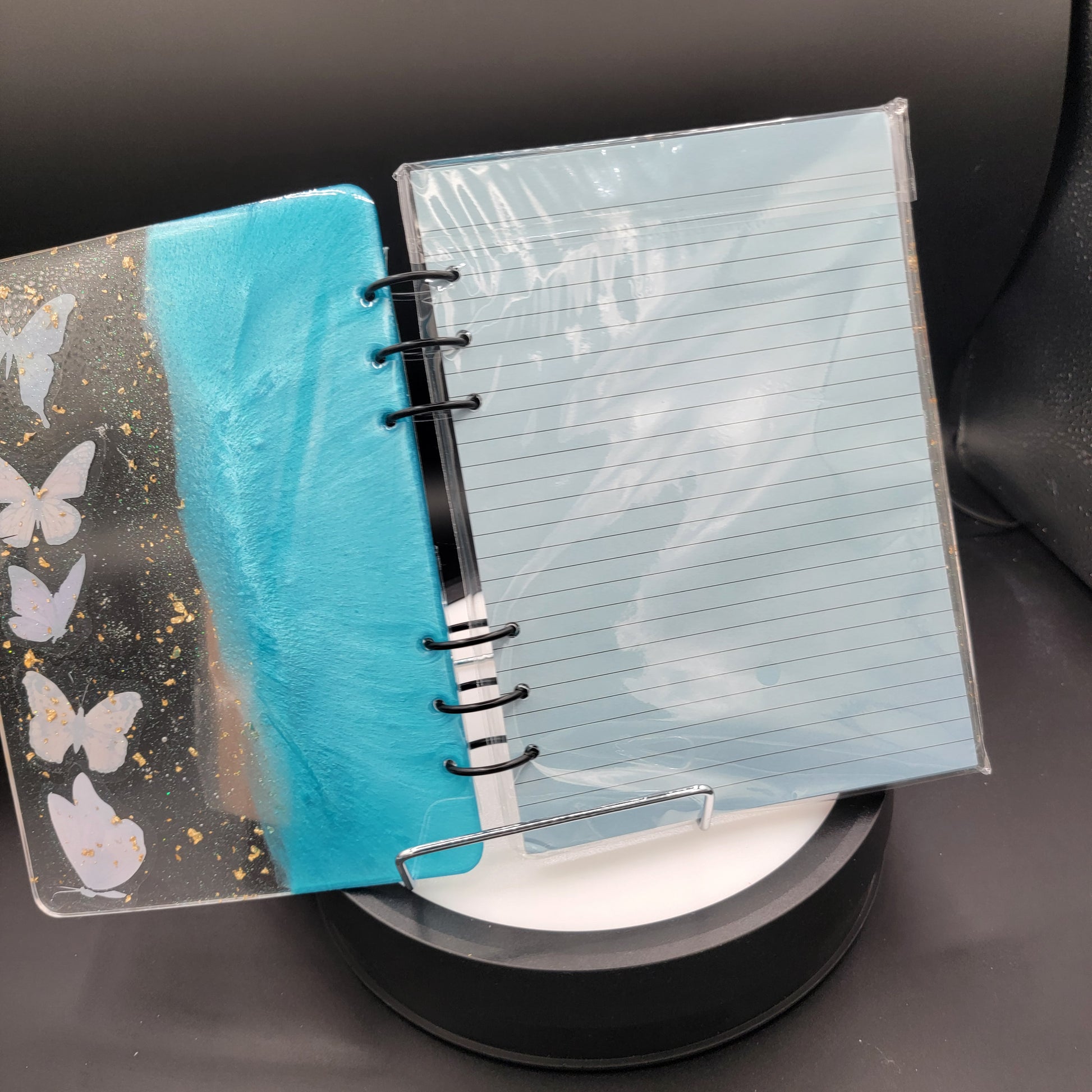 Notebook with floral design on cover and blue interior pages.
