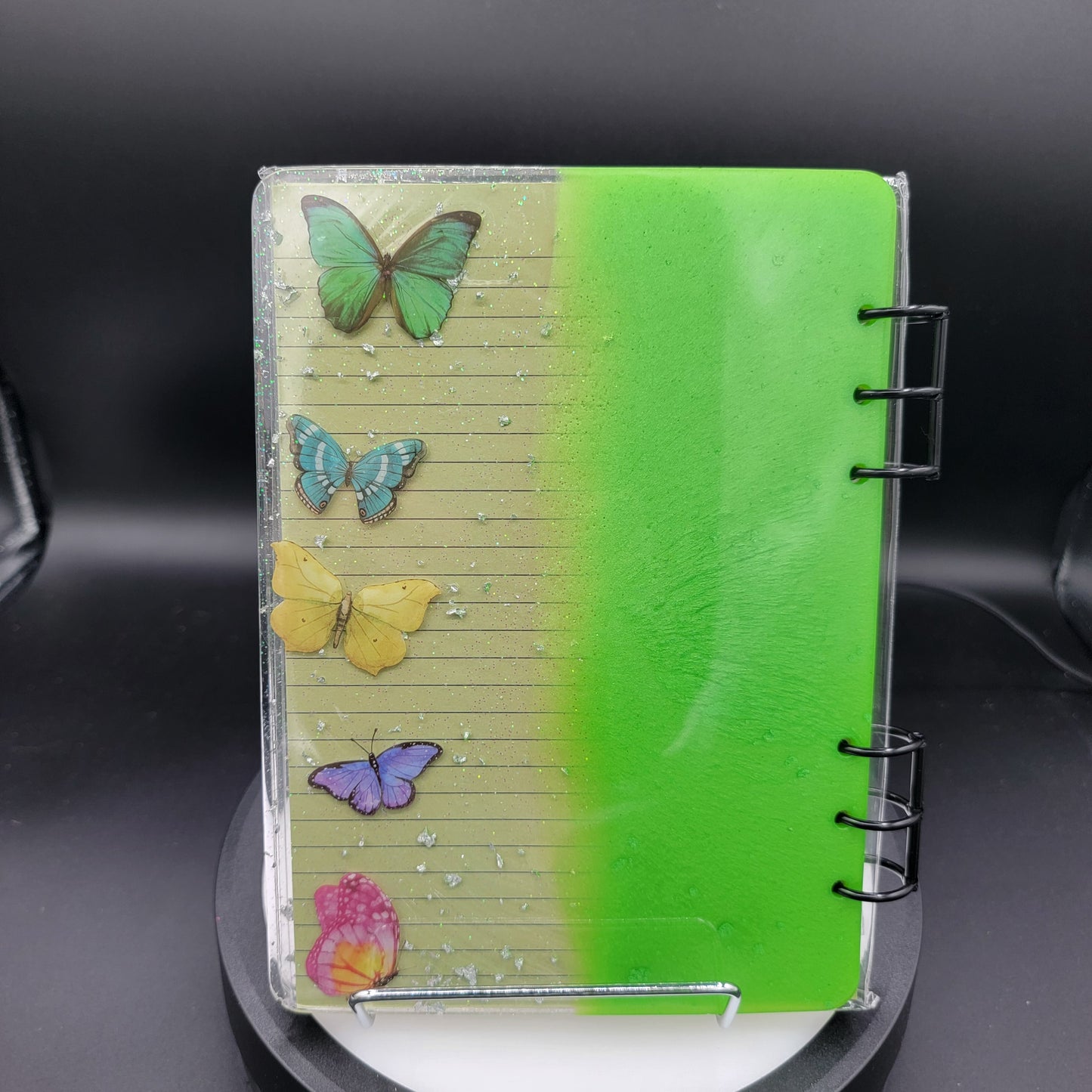 Small notebook with colorful butterfly designs on a black background