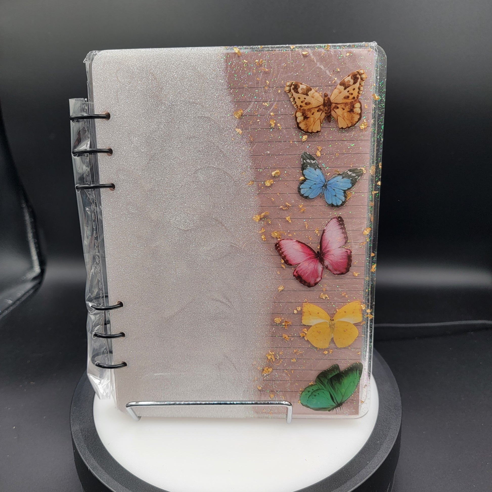 Notebook with butterfly decorations under a lamp
